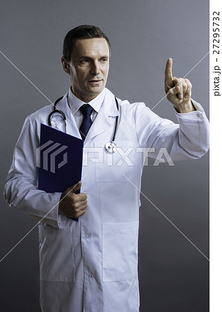 Confident doctor pointing his finger up Confident doctor pointing his finger up 27295732