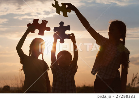 Silhouette of three happy children which playing on the field at 27298333