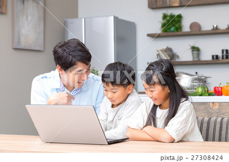 パソコンを使う家族 父親 お父さん 姉弟 勉強 ダイニングキッチン ライフスタイル 宿題する小学生の写真素材