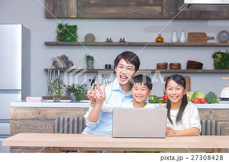 パソコンを使う家族 父親 お父さん 姉弟 勉強 ダイニングキッチン ライフスタイル 宿題する小学生の写真素材