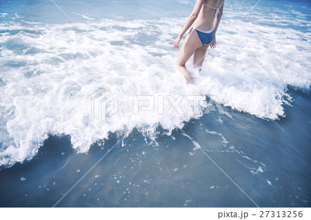 Woman walking into waves at the beach 27313256