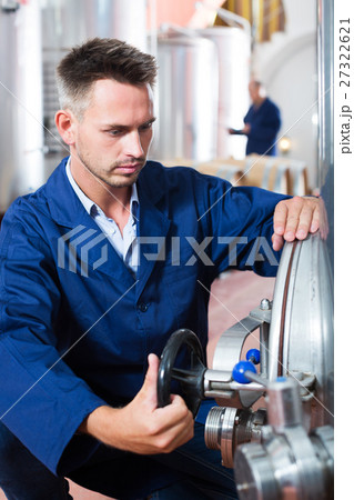 Man working on secondary fermentation equipment Man working on secondary fermentation equipment 27322621