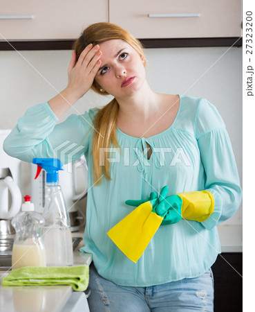 Young housewife tired dusting in domestic kitchen 27323200