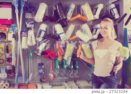 cheerful woman customer buying painting roller in household store 27323284