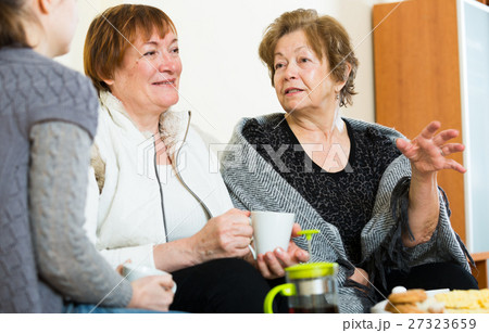 Young girl paying visit to senior grandmothers Young girl paying visit to senior grandmothers 27323659