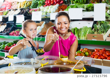 Woman with girl buying pickled olives 27323796