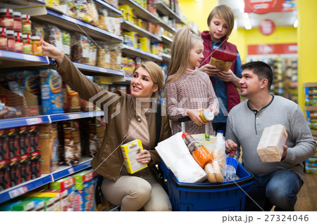 Happy family of four purchasing food together Happy family of four purchasing food together 27324046