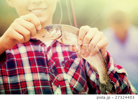 teenager boy holding catch fish on hook . 27324403