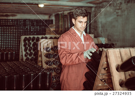 Wine maker taking care of seasoning bottles 27324935