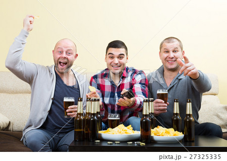 Three men watching football with beer indoor 27325335