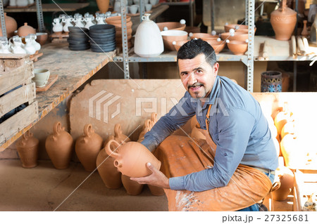 man potter holding ceramic vessels in atelier man potter holding ceramic vessels in atelier 27325681