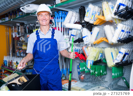 smiling workman in hardhat buying painting roller smiling workman in hardhat buying painting roller 27325769