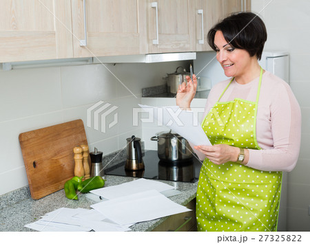 Happy housewife reading insurance contract 27325822