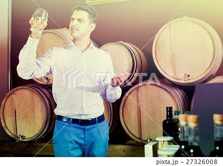 Portrait of man enjoying liquor sample in glass 27326008