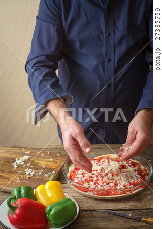Man makes homemade pizza 27335759