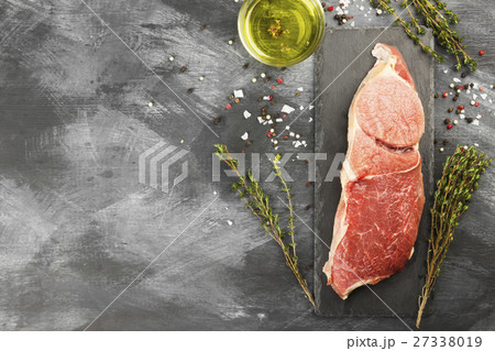 Piece of raw meat of beef on a slate board Piece of raw meat of beef on a slate board 27338019