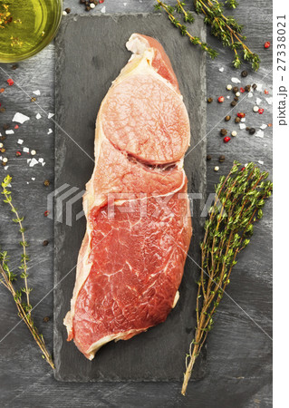 Piece of raw meat of beef on a slate board Piece of raw meat of beef on a slate board 27338021