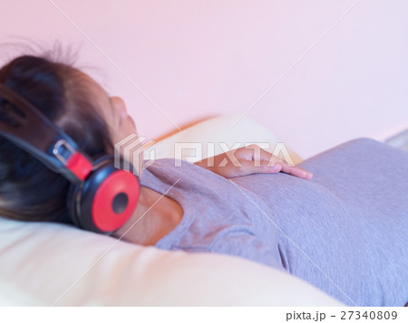 Pregnant woman Lie down and listen to music. 27340809