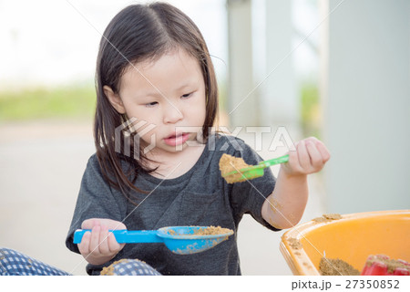 Little asian girl playing sand in sandbox Little asian girl playing sand in sandbox 27350852