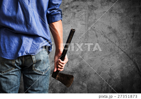 A guy holding old rusty axe,on concrete background 27351873