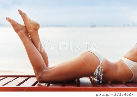 beautiful young slim woman legs sunbathe on beach beautiful young slim woman legs sunbathe on beach 27354637