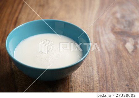 fresh milk in the blue bowl on wood table with 27358685