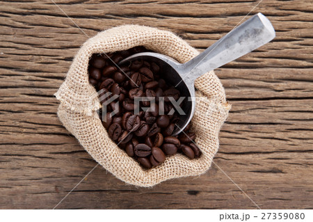 a bag of brown roasted coffee with scoop on wood b 27359080