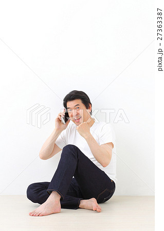 電話をかけるミドル男性　胡座 27363387