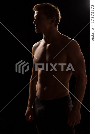 Male fitness model showing muscles in studio 27373572
