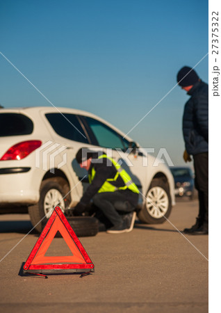 Car repairman changing flat tire after breakdown Car repairman changing flat tire after breakdown 27375322