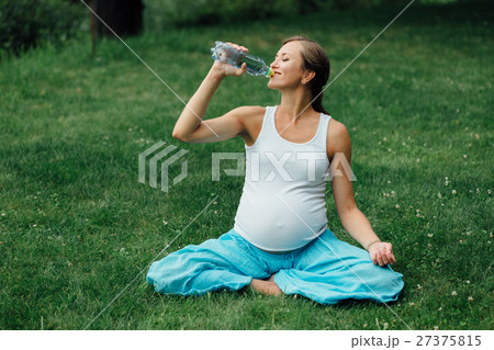 pregnant yoga woman drinking water from a bottle 27375815