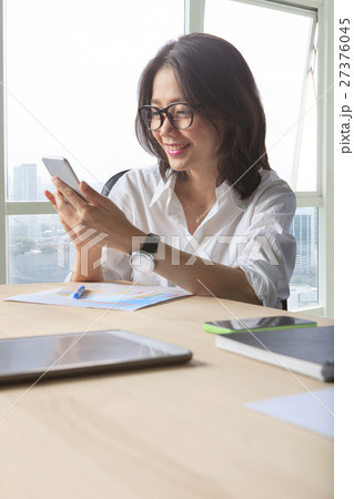 office table scene of asian working woman reading message on mob office table scene of asian working woman reading message on mob 27376045