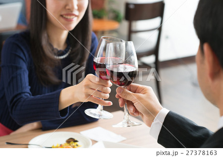 レストランで赤ワインを飲みながら食事するカップル レストランで赤ワインを飲みながら食事するカップル 27378163