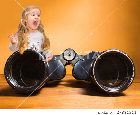 Happy little girl and binoculars over orange 27381511