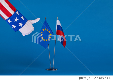 Two flags and hand on a blue background, 27385731