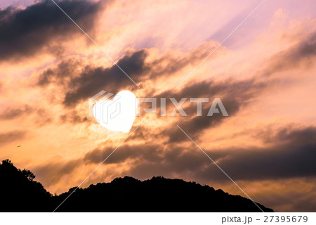 雲間から差す光 空背景画像 ラブラブイメージ ハートの写真素材