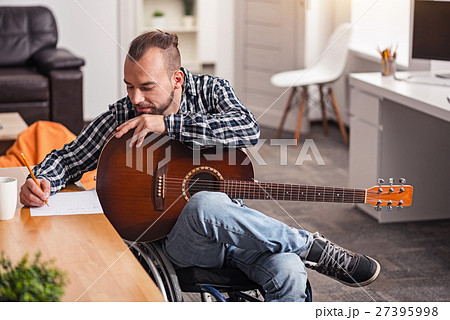 Focused disabled man engaged in songwriting 27395998