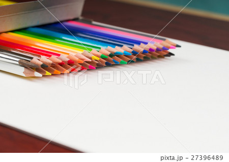 Multicolored pensils in the box on a wooden table. Multicolored pensils in the box on a wooden table. 27396489