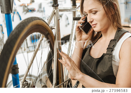 Positive worker repairing the bicycle and talking 27396583