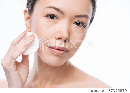 Pretty cheerful woman cleaning her face Pretty cheerful woman cleaning her face 27396830