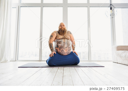 Funny fat man relaxing on sport mat 27409575