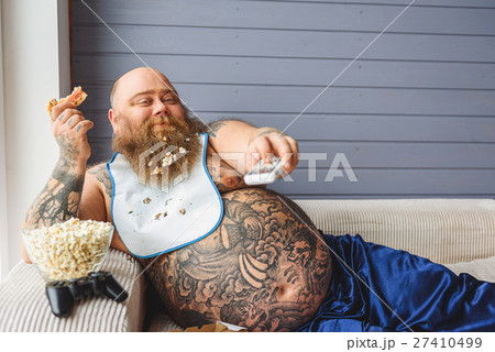 Lazy thick guy watching tv at home Lazy thick guy watching tv at home 27410499