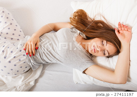 Sleepy woman sleeping in the bed. Sleepy woman sleeping in the bed. 27411197