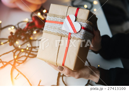 girl holding a Christmas gift in hand 27413100