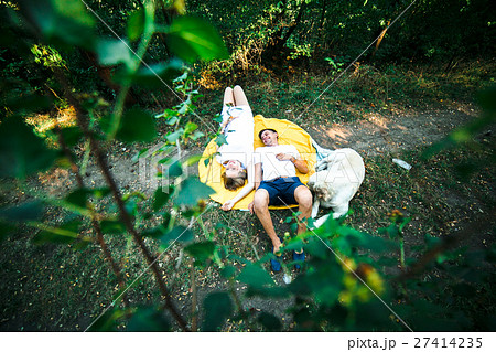 pregnant woman with husband lying in the park 27414235