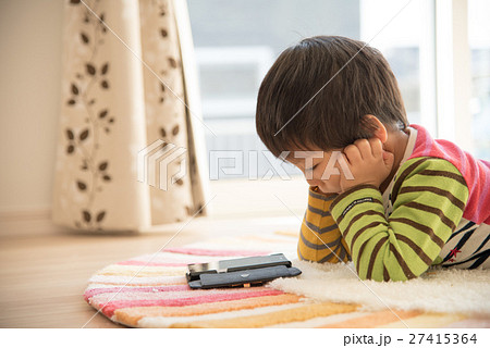 寝ころんでスマホを見る男の子 寝ころんでスマホを見る男の子 27415364