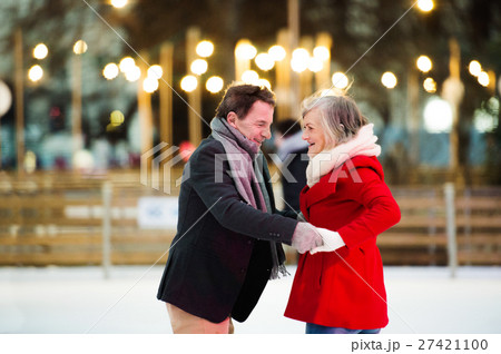 Beautiful senior couple ice skating in city centre 27421100