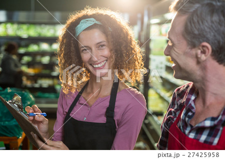 Staffs writing on clipboard in organic section 27425958