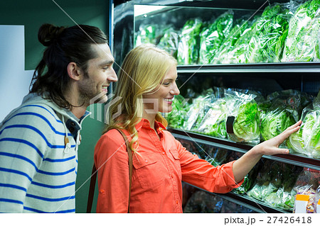 Happy couple selecting vegetables in organic section 27426418