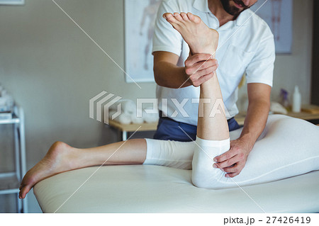 Physiotherapist giving leg massage to a woman Physiotherapist giving leg massage to a woman 27426419